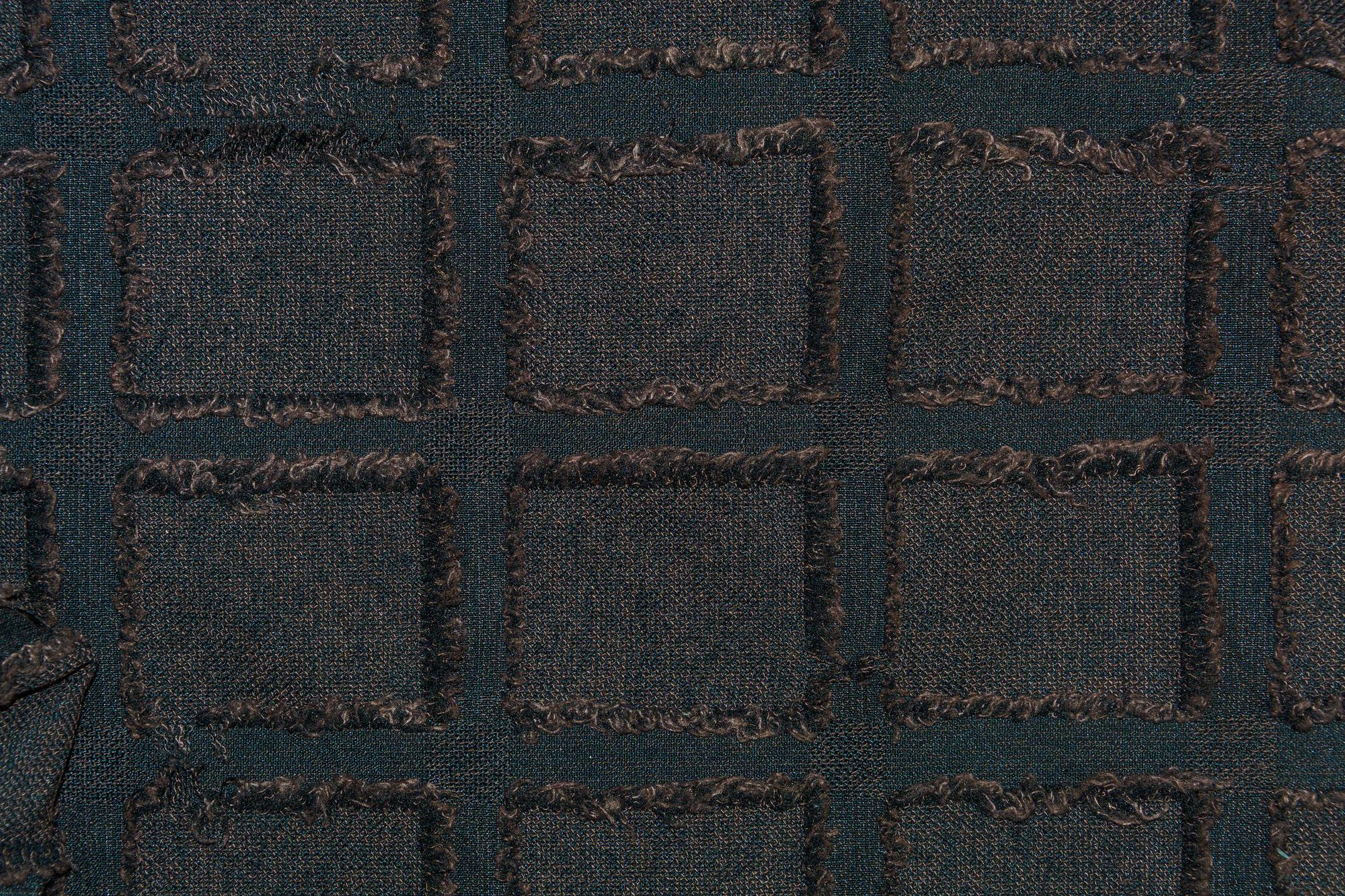 Close-up of geometric embroidered patch on dark fabric